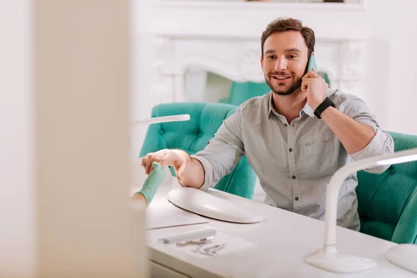 Stylish handsome man sitting in beauty salon getting manicure — Stock Photo, Image