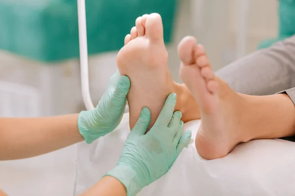 Experienced chiropodist practicing acupressure for businesswoman