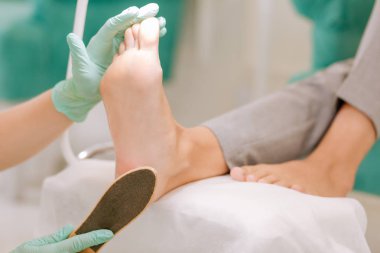 Ayak scrubber elinde tutan eldiven giymiş bakımuzmanına