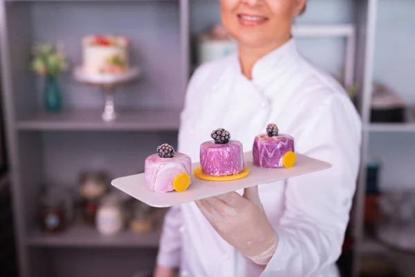 Stralende blonde-haired baker het resultaat van haar werk — Stockfoto