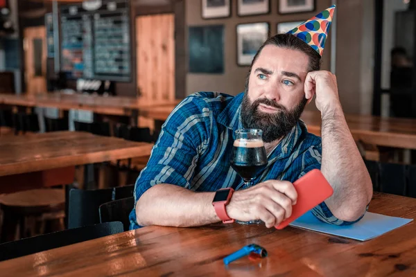 Blue-eyed man feeling shocked reading message on his phone — Stock Photo, Image