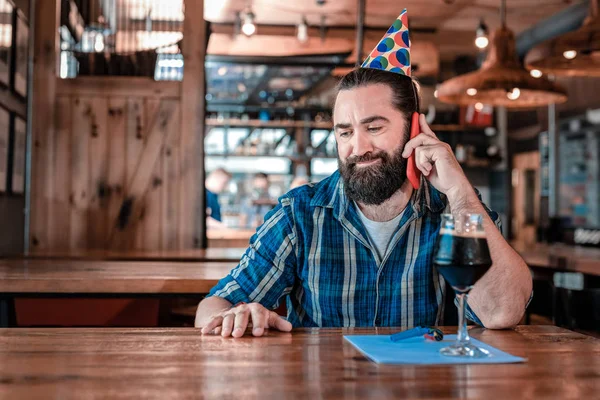 Birthday man feeling unsatisfied while sitting alone in the bar