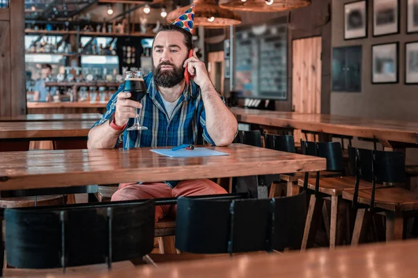 Ciemnowłosa mężczyzna niebieski kwadrat koszulkę picia piwa w pubie — Zdjęcie stockowe