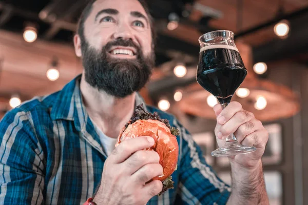 ブルー ・ アイド ・ ハンサム バーガーを食べて、ビールを飲んで良い感じ — ストック写真