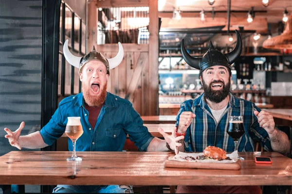 Dwóch przyjaciół Wikingów na sobie kapelusz, uczucie emocjonalnej siedzi w pubie — Zdjęcie stockowe