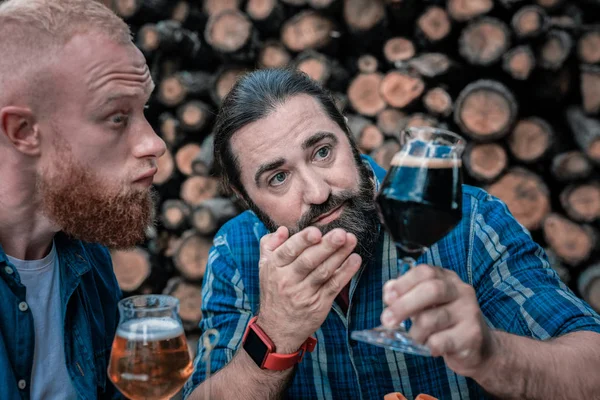 Tmavé vlasy fanoušek piva drží sklo s chutné tmavých piv — Stock fotografie