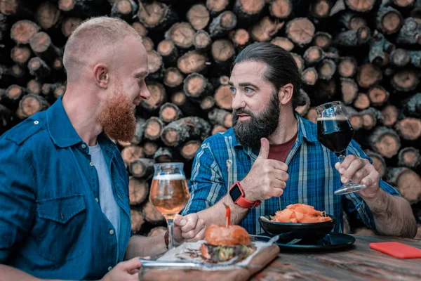 Homme mûr se sentant satisfait après avoir bu une bière artisanale sombre avec des collations — Photo