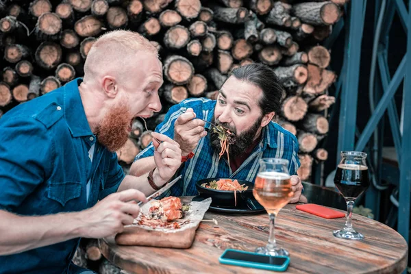 おいしい食事をしながら良い感じ 2 つの空腹の男性 — ストック写真