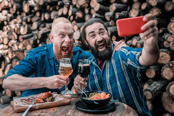 Dos hombres de negocios maduros haciendo fotos juntos sentados en el pub —  Fotos de Stock