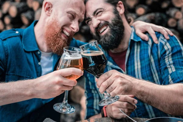 Hombre pelirrojo abrazando a su amigo mientras beben cerveza juntos —  Fotos de Stock