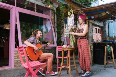 Vazoda Çiçekler koyarak yaratıcı yaz teras sahibi