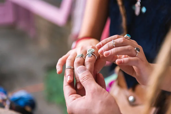 Uomo che tiene per mano la sua ragazza indossando molti bei anelli — Foto Stock