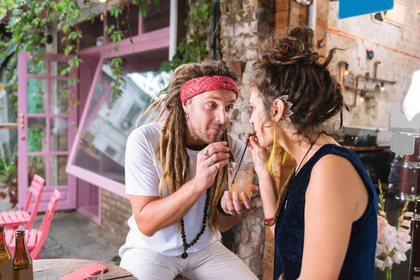 Hippie muž spojující jeho přítelkyně pít koktejl — Stock fotografie