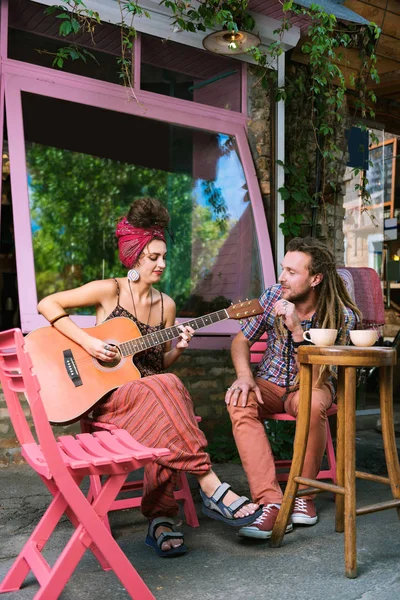 Bruna hippie donna a suonare la chitarra per il suo uomo — Foto Stock