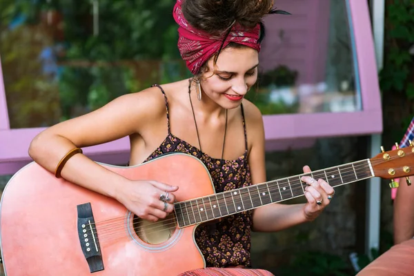 Bella musicista donna che suona la chitarra seduta nel caffè — Foto Stock