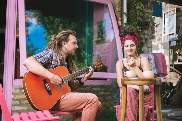 Inspirado hippie homem tocando na guitarra para sua namorada — Fotografia de Stock