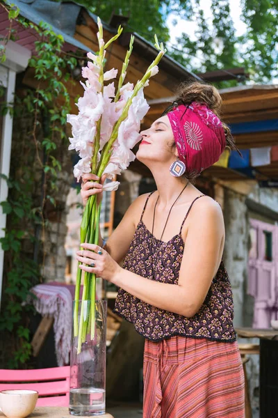 Kreative weibliche Hippie riecht schöne weiße Blumen — Stockfoto