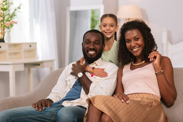 Alegre chica feliz de pie detrás de sus padres —  Fotos de Stock