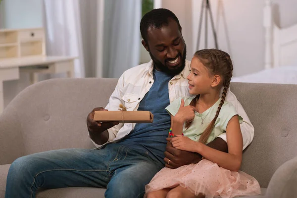 Hombre feliz positivo dando un regalo a su hija —  Fotos de Stock