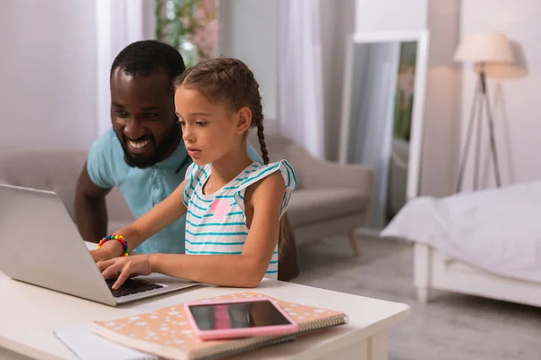 Intelligente ragazza seria digitando con suo padre — Foto Stock