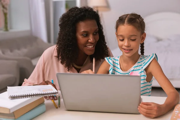 Glad trevlig kvinna att hjälpa dottern med läxor — Stockfoto