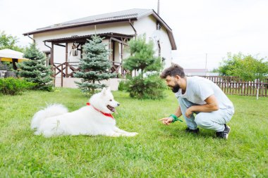 Esmer adam onun sabah yazlık beyaz köpek ile harcama