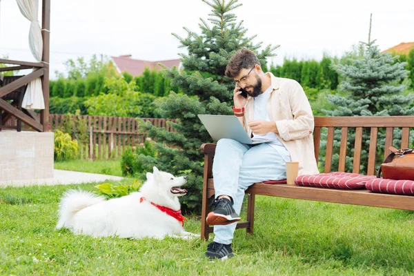 Ocupado freelancer contestando llamadas mientras trabaja fuera — Foto de Stock