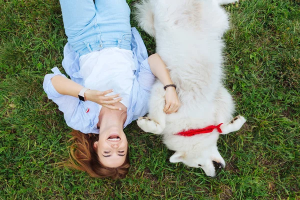 Mulher engraçada rindo enquanto brincava com seu cão branco — Fotografia de Stock
