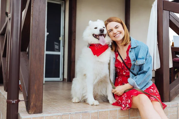 Mujer radiante que viene a la casa de verano con su perro — Foto de Stock