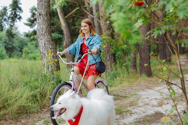 Fashionable happy woman riding bike on warm summer day — Stock Photo, Image