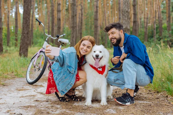 Blonďatá žena dělat selfie se svým manželem a psem — Stock fotografie