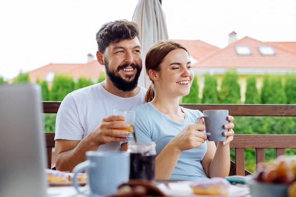 Pareja feliz bebiendo jugo de naranja y café por la mañana — Foto de Stock