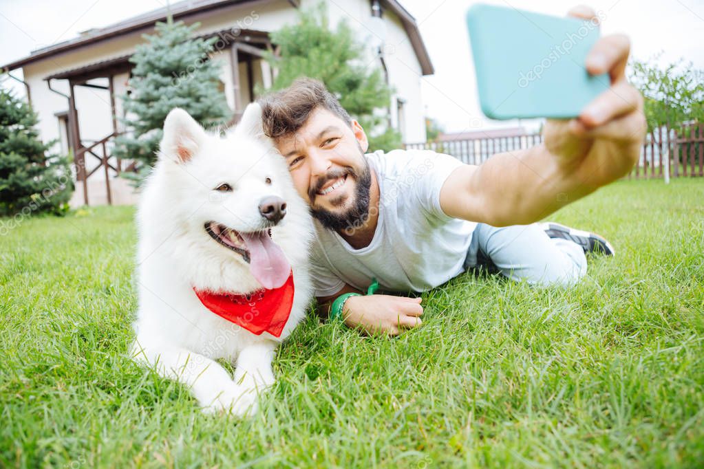 Funny white husky posing for photo with his owner