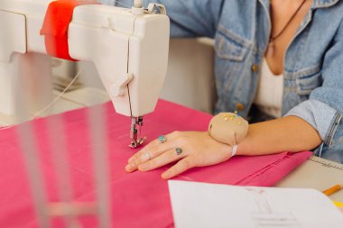 El dikiş makinesi yanında pembe tekstil üzerinde Kapat