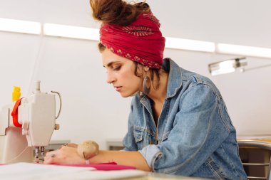 Atelier dikiş makinesi dikkatle üzerinde ciddi terzi