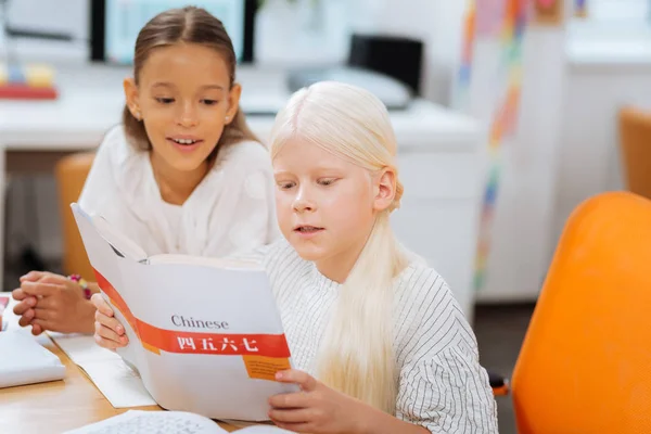 Meninas inteligentes lendo um livro muito atentamente — Fotografia de Stock