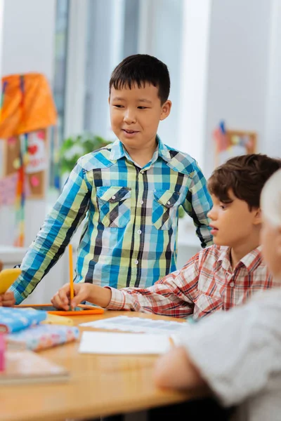 Garçon confiant et souriant regardant les camarades de classe — Photo