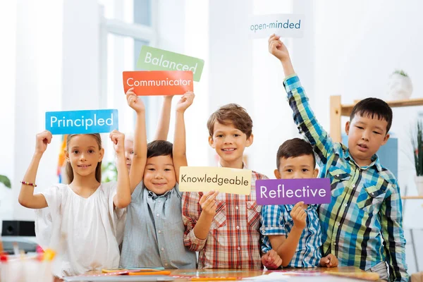 Schoolkinderen verschillende kleurrijke tabellen in hun handen houden — Stockfoto