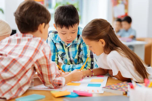 Concentrated attentive children drawing a picture together — Stock Photo, Image