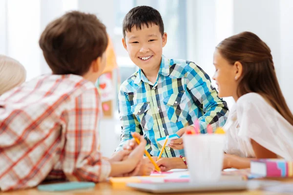 Cheerful boy drawing a picture with classmates — Stock Photo, Image