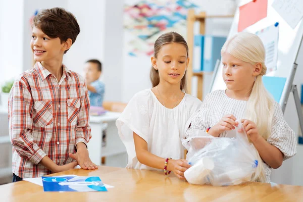 Красиві школярки, що збирають пластиковий сміття в класі — стокове фото