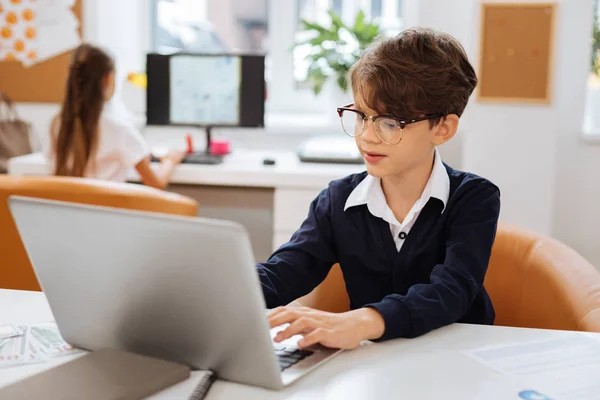 Smart Boy mit einem Laptop in einem Klassenzimmer — Stockfoto