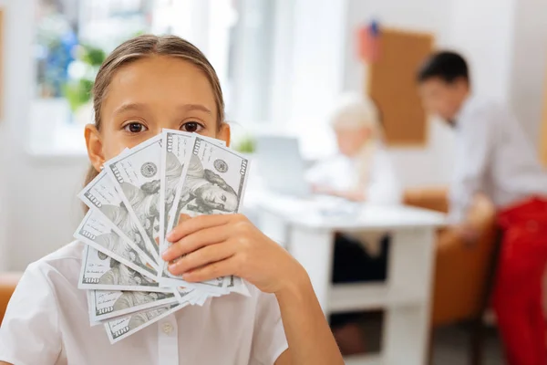 Bonito menina segurando dinheiro em uma mão — Fotografia de Stock