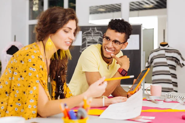 Costureiras positivas sorrindo ao discutir o desenvolvimento do atelier — Fotografia de Stock