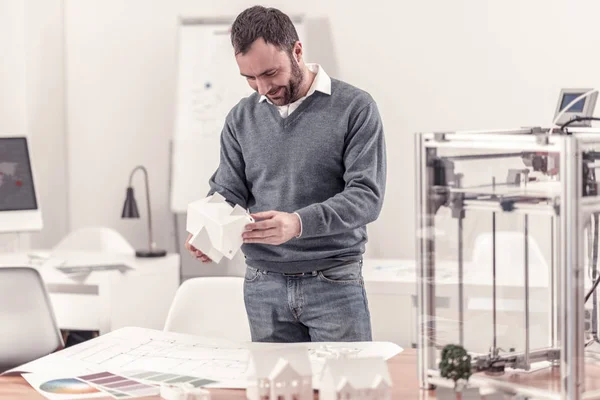 Ingenious designer holding model of a house — Stock Photo, Image