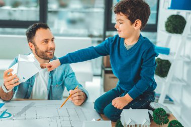 Olumlu memnun genç adam çocukla oynuyor
