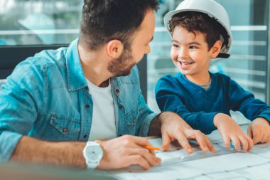 Baba ile oynayan neşeli esmer çocuk