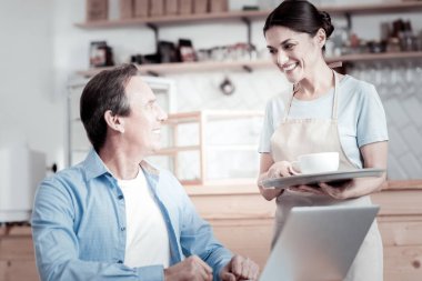 Kahve bir tepsi üzerinde tutarak ve ziyaretçi seyir garson gülümseyerek