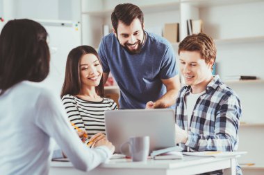 Neşeli genç öğrenciler yaptıkları proje tartışıyor