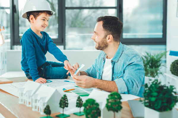 Веселый мальчик помогает своему папочке с выбором
